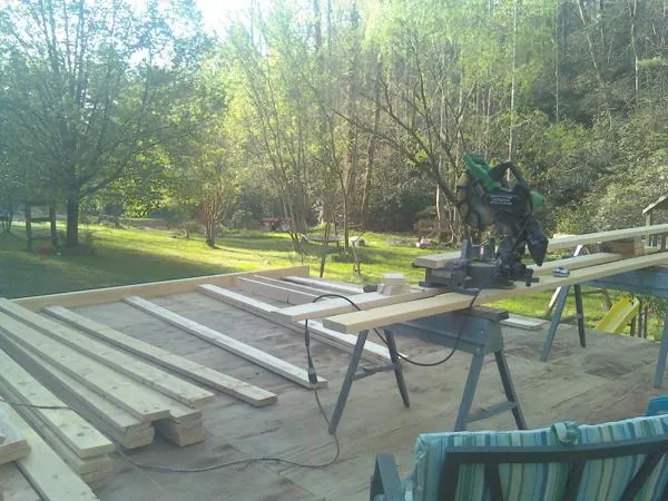 Miter saw and framing lumber on a deck under construction in Ocilla